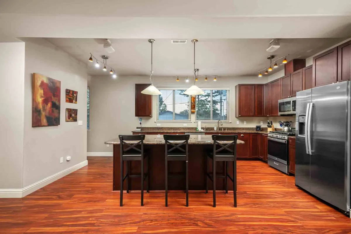 A modern, welcoming kitchen with an island countertop, stainless steel appliances, and wooden cabinetry. Artwork on the wall adds a stylish touch. The space is perfect for preparing healthy, home-cooked meals after an active day outdoors.